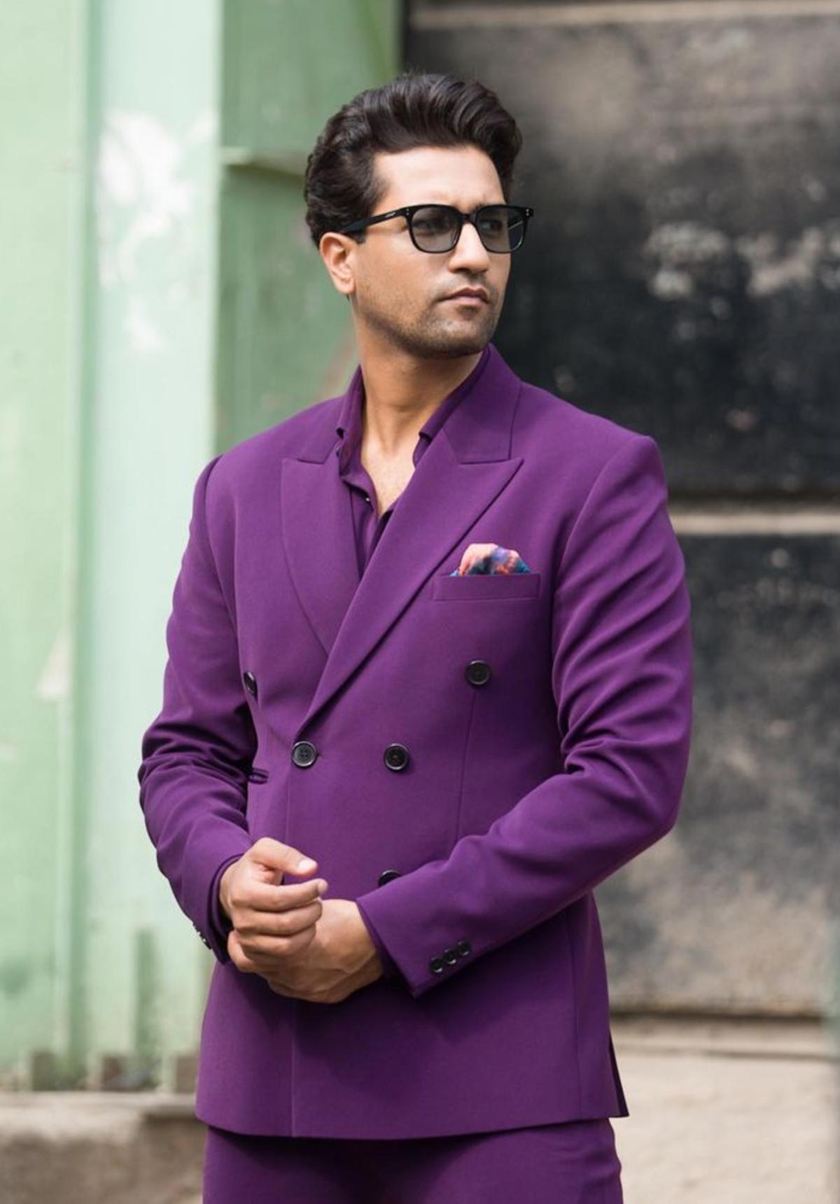 After making an impressive appearance in a pastel green suit at the season 7 of the popular reality talk show, 'Koffee With Karan', Vicky has once again donned an all-purple suit and we are not complaining! The 'Govinda Naam Mera' actor recently dropped a series of photos on Instagram, where he can be seen flaunting an all-purple suit set and oh boy! He simply nailed it. The bold colour of his ensemble reverberated his infectious energy and it went pretty well with his persona. Dipped in purple from head-to-toe, Vicky wore a matching shirt underneath his double-breasted blazer. His colourful pink and blue pocket scarf made his ensemble stood out. With black sunglasses and sparkling black shoes, Vicky oozed nothing but effortless style. 